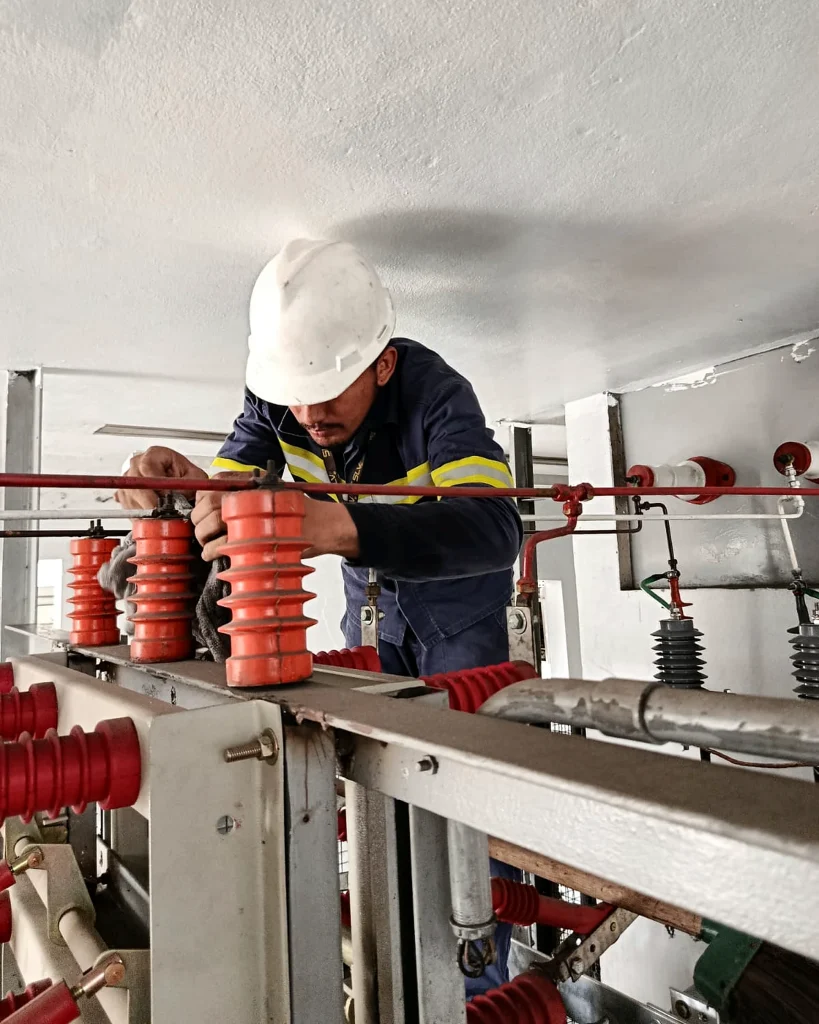 Profissional da SLV realizando manutenção em componentes de uma subestação elétrica.